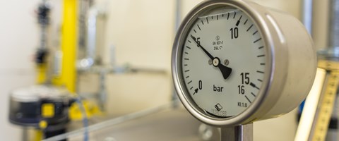 Manometer an einer Anlage mit gelben Rohren zeigt knapp fünf Bar an Manometer an einer Anlage mit gelben Rohren zeigt knapp fünf Bar an