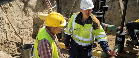 Zwei Mitarbeiter im Gespräch in einer Baugrube Zwei Mitarbeiter im Gespräch in einer Baugrube
