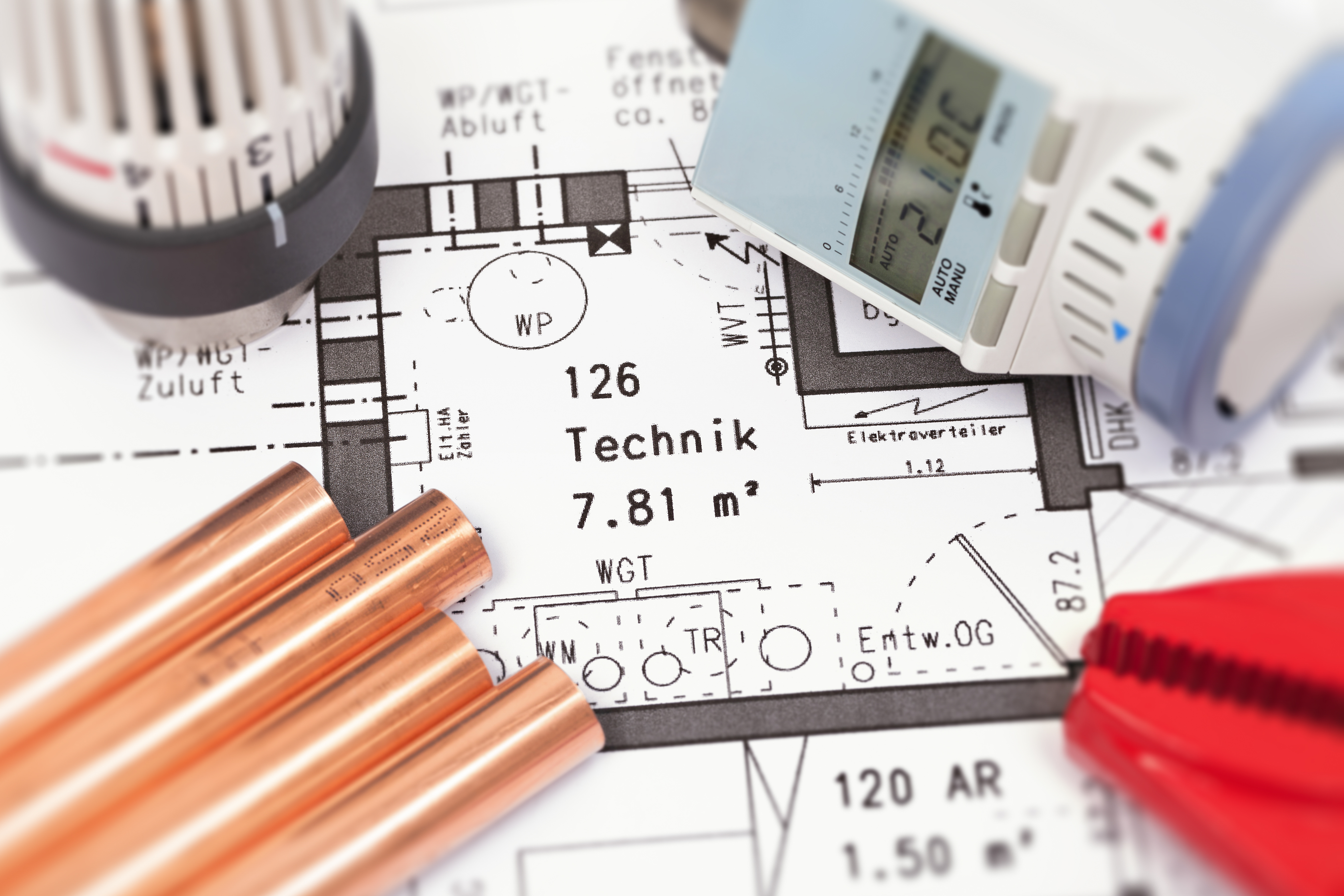 Nahaufnahme einer Bauzeichnung, auf dem Plan liegen Heizungsteile